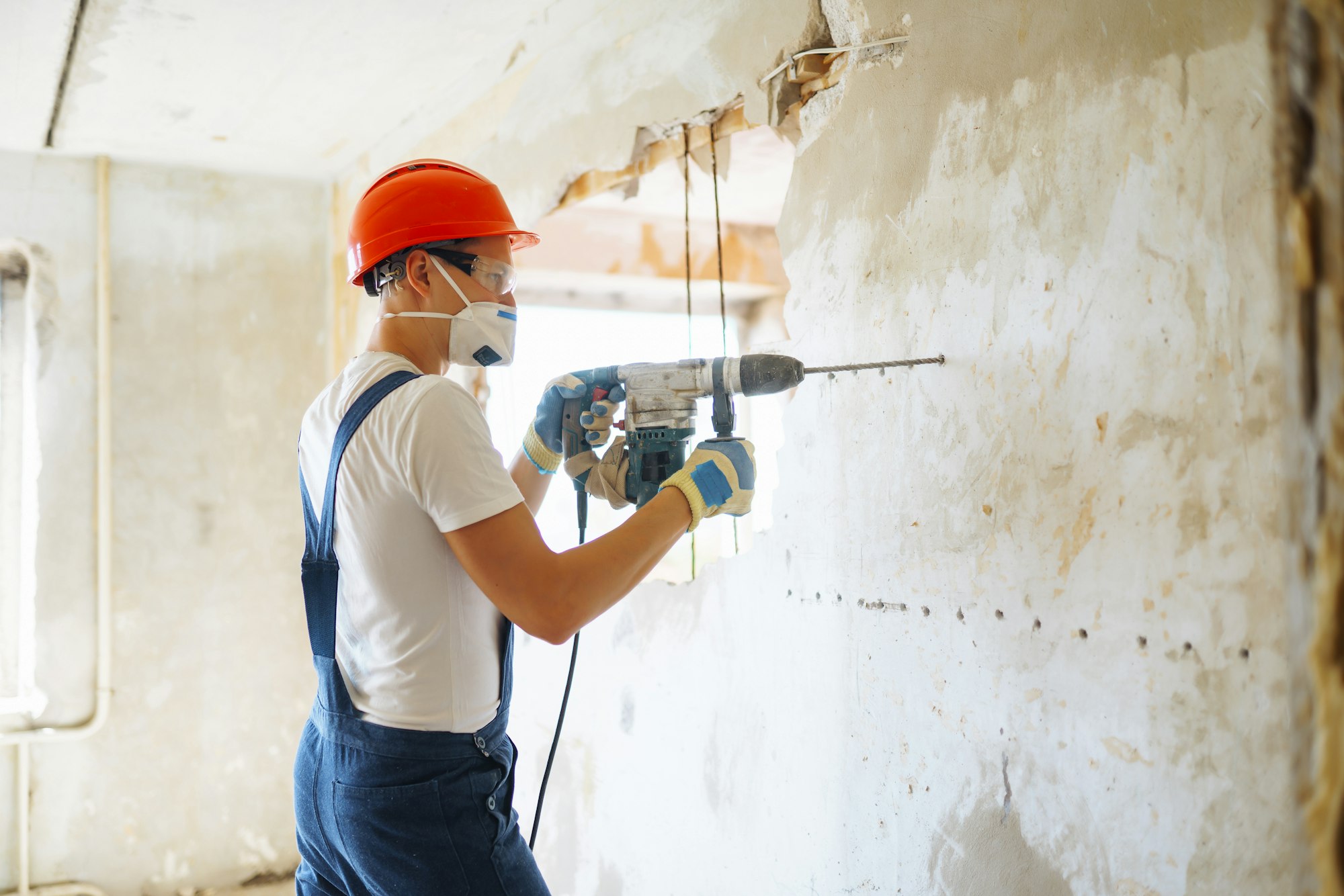 Repairer in boilersuit holding tools. Apartment repair and renovation concept. Building.